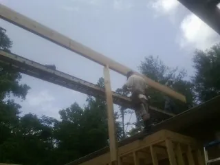 Carpenter setting a ridge beam over a new addition frame — Ice Dam Removal by Roofing Brothers in Center Valley