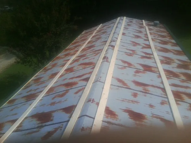 Rusted metal roof panels with new wood purlins before replacement — Storm Damage Roof Repair in Center Valley by Roofing Brothers