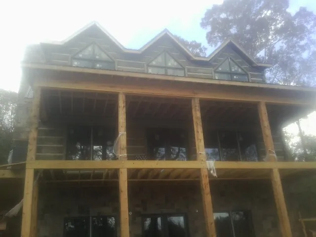 Dormers and porch framing on a large log home under construction — Roof Coating work by our crew in Center Valley