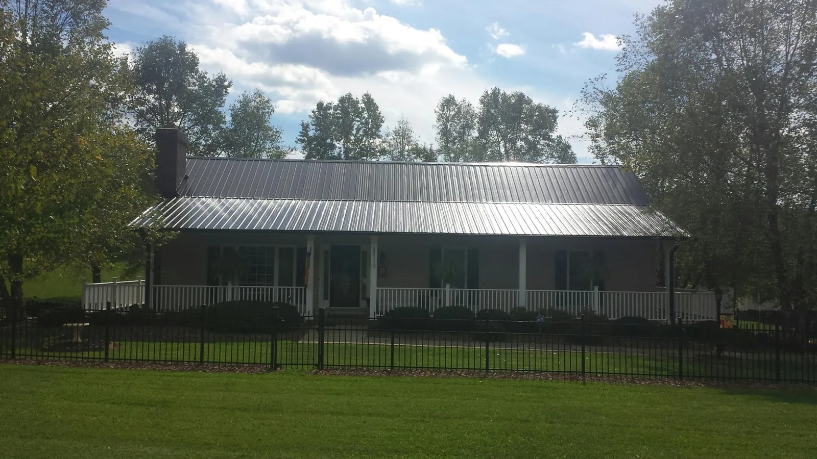 Gray metal roof on a brick ranch with a full width front porch — Gutter Guard Installation work by our crew in Center Valley
