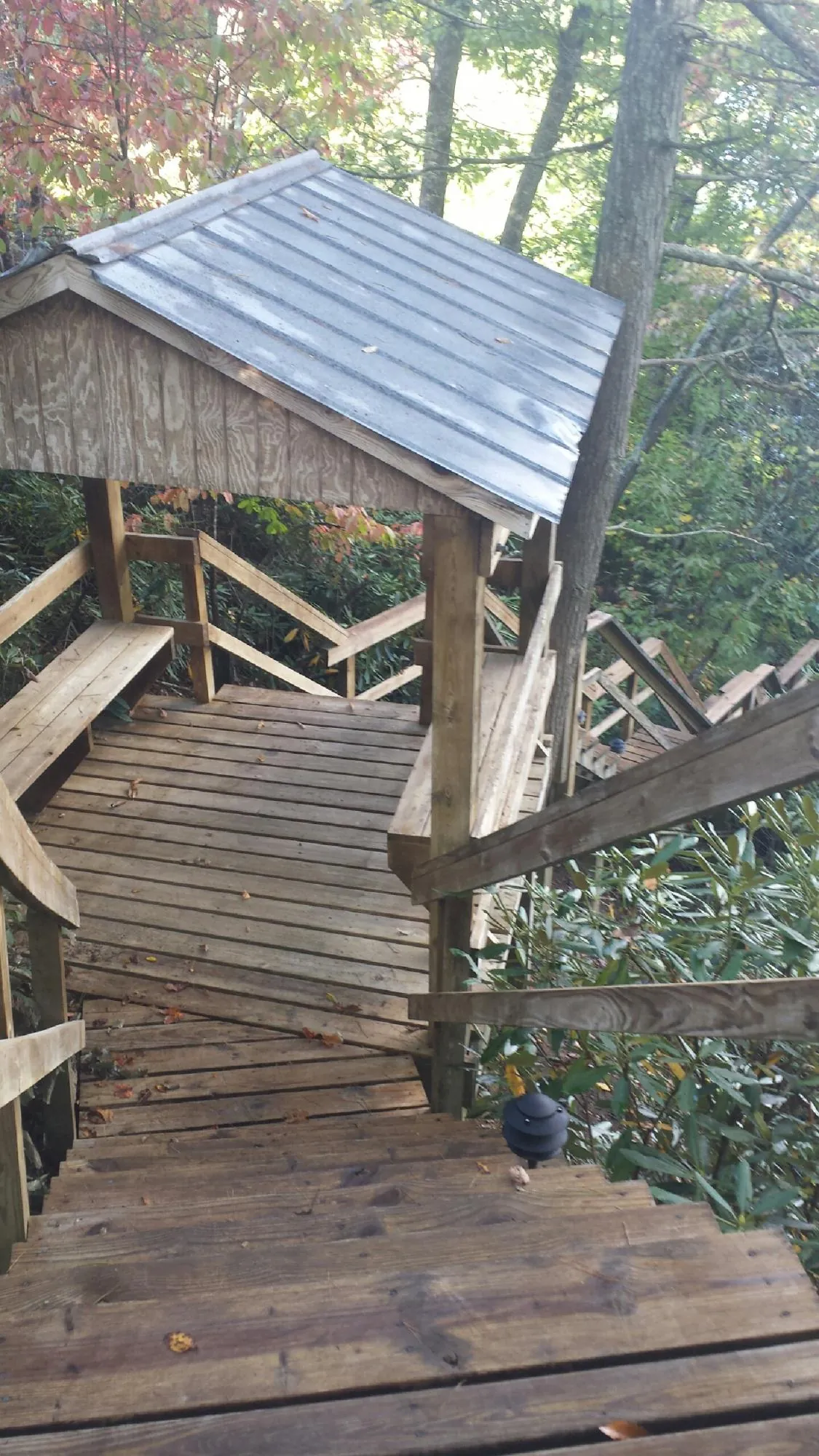 Metal roofed shelter over wooden steps on a wooded walkway — Skylight Repair & Installation work by our crew in Center Valley